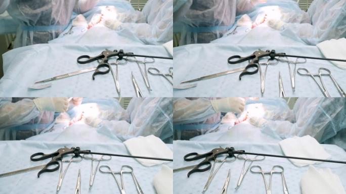 腹腔镜肠道手术即将结束。手术器械和腹腔镜钳位于盐上。医生缝合伤口。腹腔镜手术的概念。