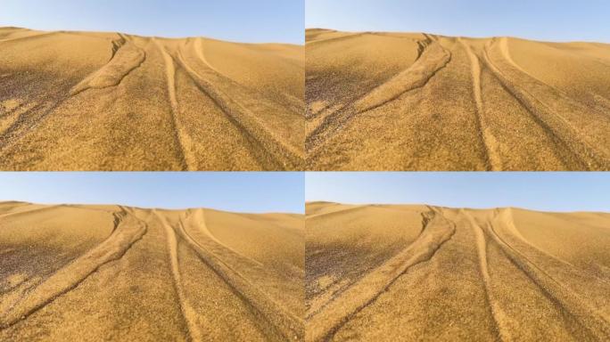 沙丘沙漠沙滩抽象镜头。沙粒在风中飘扬。阳光反射在折叠的沙子表面上。