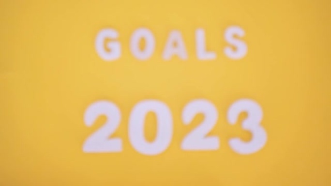白色铭文目标2023在黄色背景上。从模糊拍摄到清晰拍摄的过渡