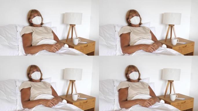 一名脸上戴着白色防护面具的白人妇女躺在卧室的雪白床上。她被隔离以防止新型冠状病毒肺炎病毒的传播。
