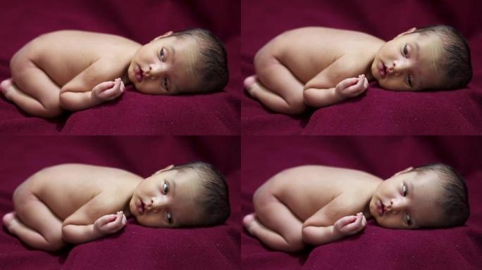 新生婴儿躺在红色天鹅绒布上，从不同角度表情可爱