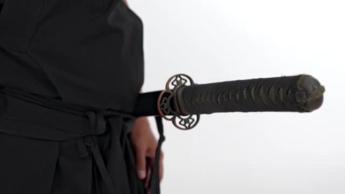 一名日本武士，手里拿着他的剑，穿着和服的武士刀