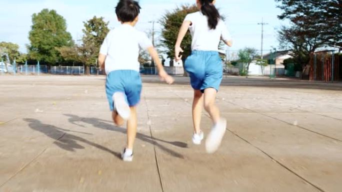 小学男女生在学校操场跑步