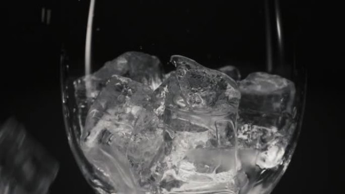 冰块掉落空透明玻璃特写。鸡尾酒准备概念