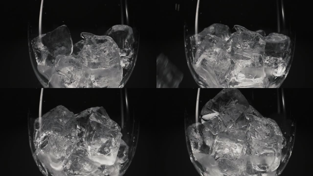 冰块掉落空透明玻璃特写。鸡尾酒准备概念