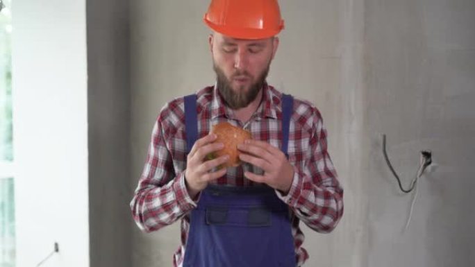 午休时戴头盔的建筑工人吃汉堡