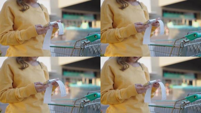 近距离使用智能手机在杂货店检查金额账单。