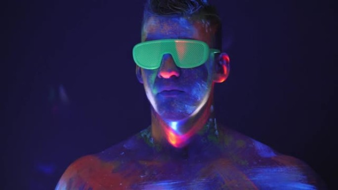 一个身上有紫外线图画的人站在荧光灯的灯光下。