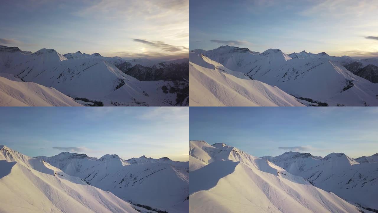 冬季日出时，雪山山坡上满是粉末的空中飞车在滑雪胜地进行自由滑行。偏远地区的山脉覆盖着初雪。高加索山峰