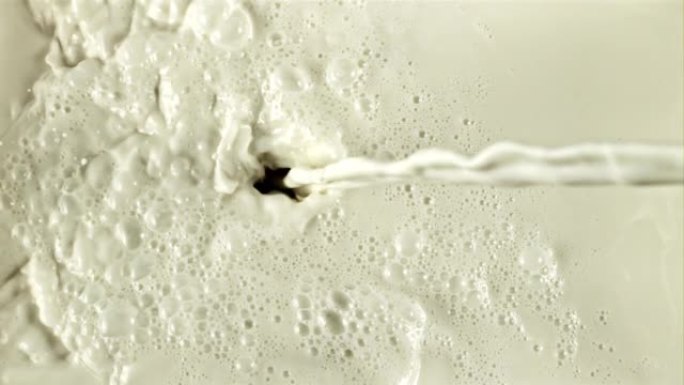 一股牛奶流淌着飞溅和气泡。以1000 fps的高速相机拍摄。