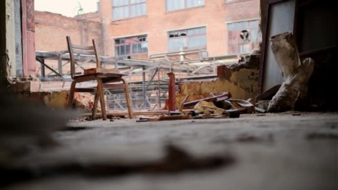 木制旧椅子站在废弃的建筑物或工厂中间，没有墙壁。日光，黄光落在座位上。孤独和后启示录的概念
