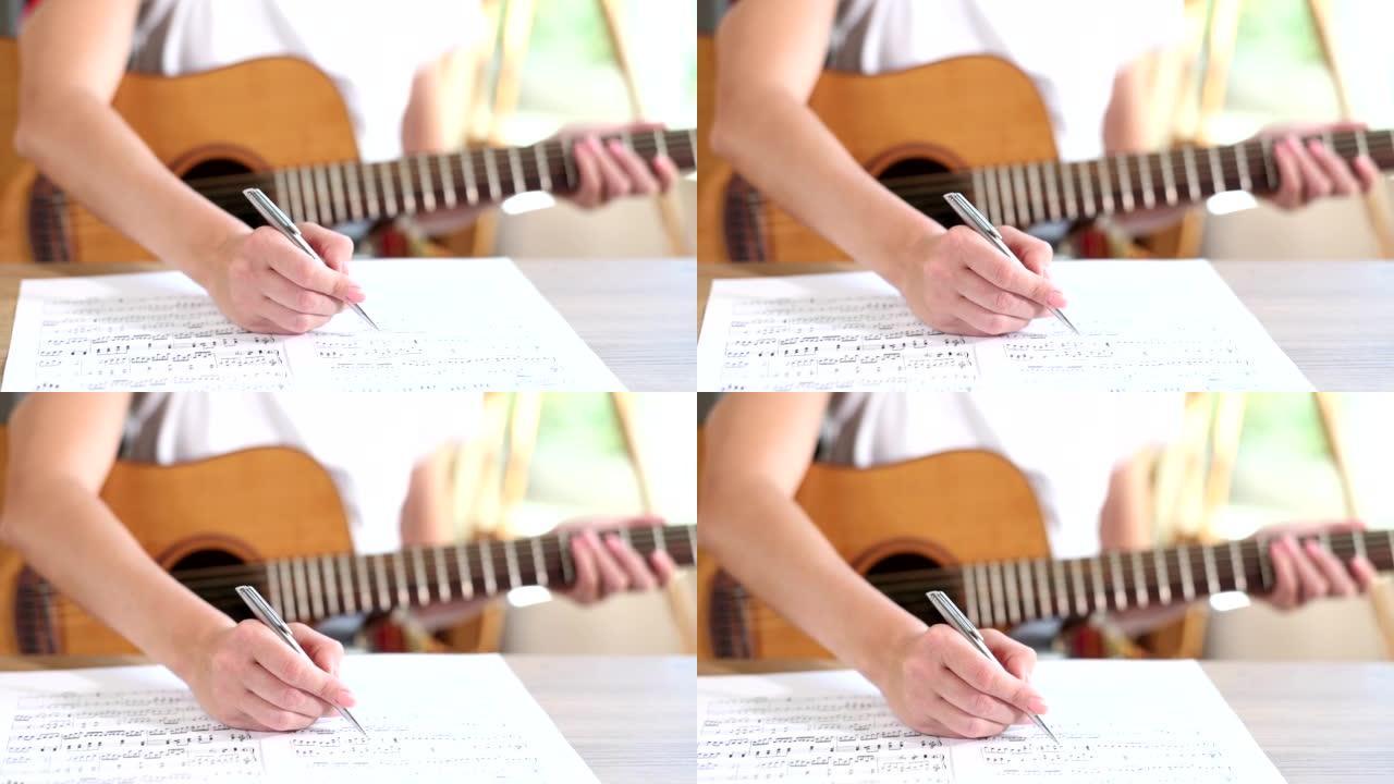 特写词曲作者享受快乐的爱好，并用原声吉他在纸上写下音符