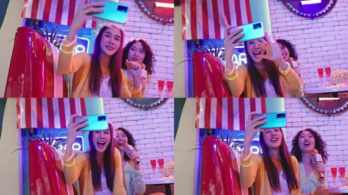 两名年轻亚洲女性的4k视频片段正在一家餐厅举行庆祝圣诞歌唱派对。开心快乐，带着微笑玩得开心。休闲活动