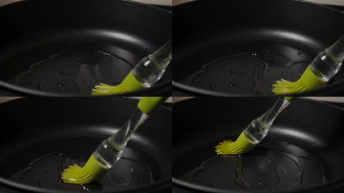 慢动作男子将橄榄油从瓶中润滑到煎锅中，特写镜头。宏观射击厨师将植物油润滑到煎锅中，以进行慢动作烹饪。