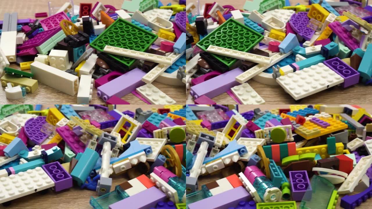 多莉在一名儿童设计师的一堆塑料零件上开枪。白色桌子上的塑料五彩块。