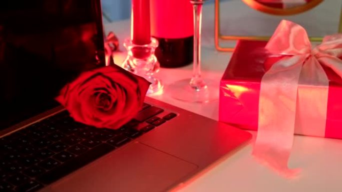 在线约会概念红色蜡烛一瓶葡萄酒和笔记本电脑前的礼物