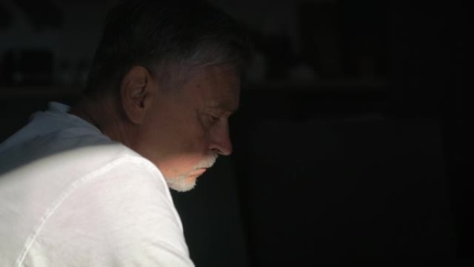 有精神问题的白人老人坐在黑暗中。用8k的红氦相机拍摄。