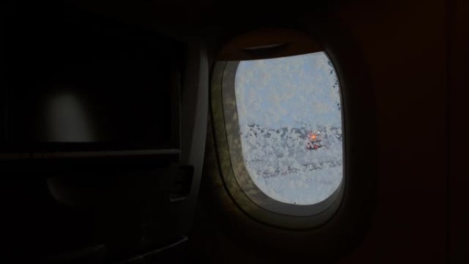 4k稳定的镜头显示，飞机的照明器在外面恶劣的冬季天气被关闭，为长途长途飞行做准备。