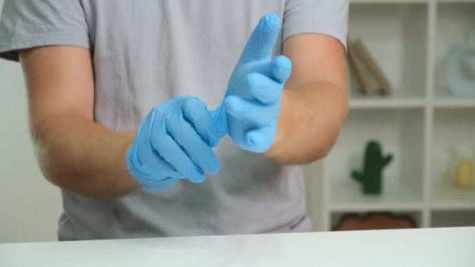 男人们戴着医用蓝色手套的手特写。那个人戴着蓝色丁腈手套。