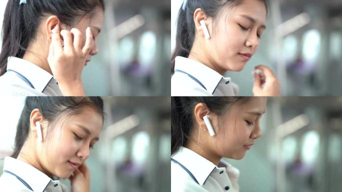 亚洲女子戴耳机在电联车上听音乐