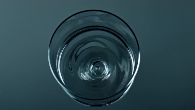 水滴落杯俯视图。透明的纯净液体荡漾