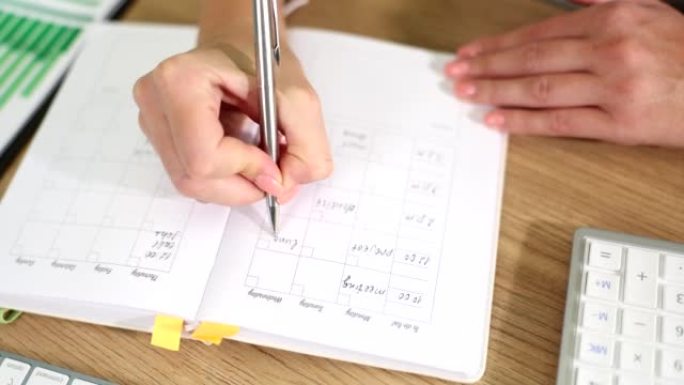 女人为预算计划和会议写笔记，待办事项清单和日记