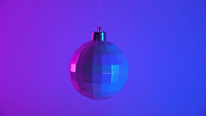 霓虹灯下的圣诞球。新年2023。球挂在蓝色粉色背景上。圣诞快乐