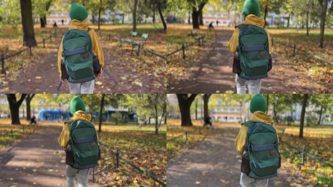 穿着黄色夹克的男孩带着绿色背包去上学