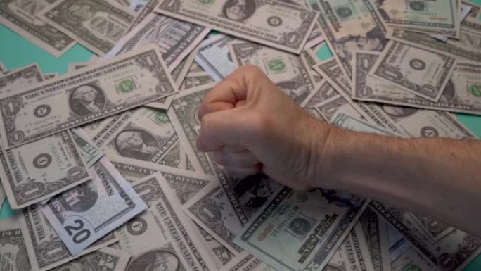 一名男子在装满美元的桌子上拳打脚踢。