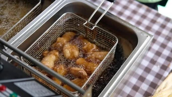 用热沸腾的油在油炸锅中拍摄鸡肉的慢动作