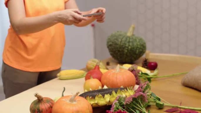 女性双手拍照智能手机秋菜餐桌感恩节