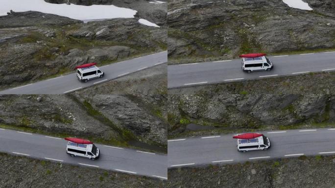 穿过挪威高地的公路上有红船的露营车的风景鸟瞰图