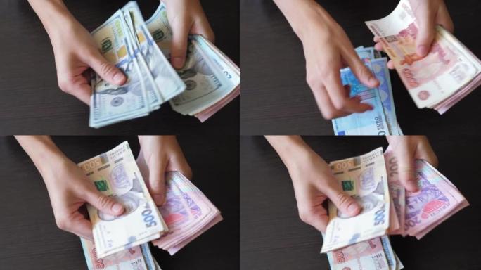 女性双手的特写放在桌子上，数钞。美元，欧元，格里夫纳，卢布。有支付金融的女孩。富婆享受现金纸币。国际