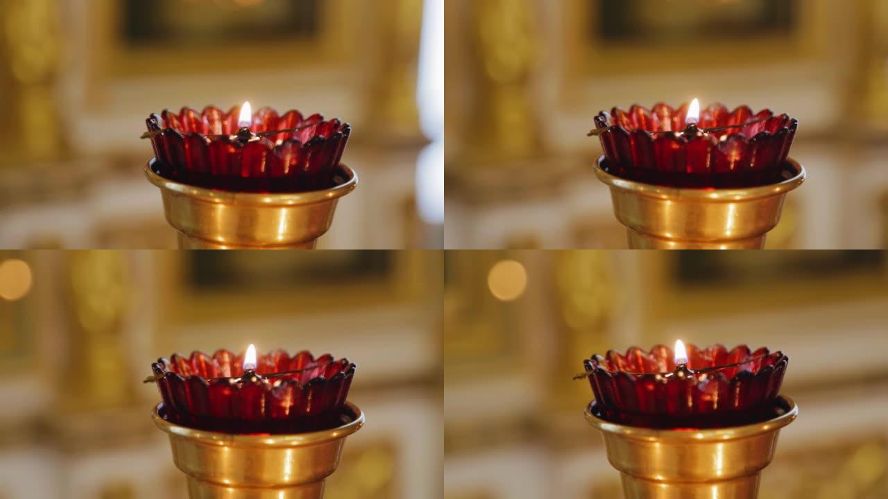 一支蜡烛在基督教教堂的碗里燃烧。用相机移动拍摄蜡烛特写