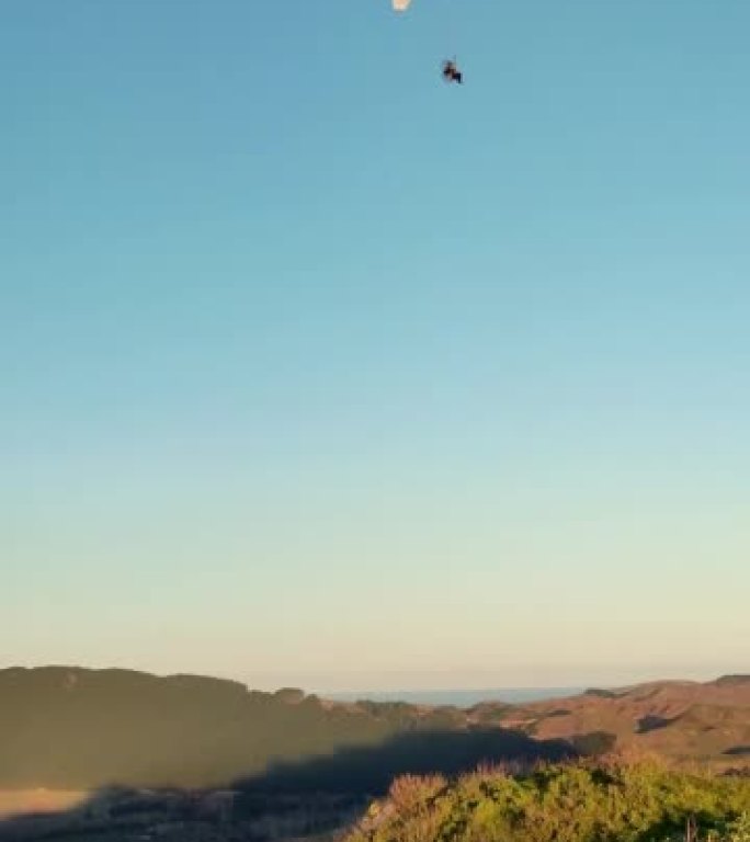滑翔伞在美丽阳光明媚的早晨飞越山腰
