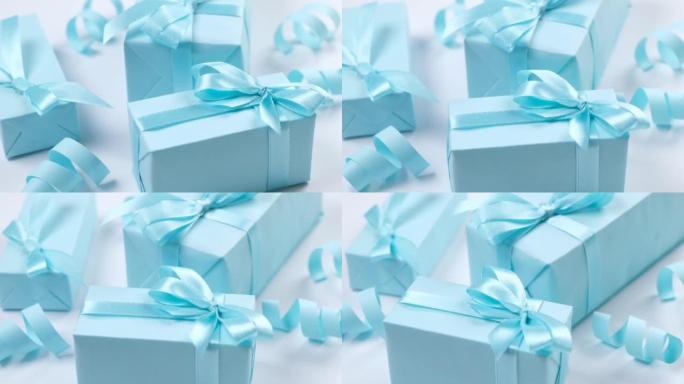 蓝色背景上带有蓝色蝴蝶结的旋转蓝色礼品盒，庆祝男孩或男人的生日，聚会或周年纪念日或新生儿的概念