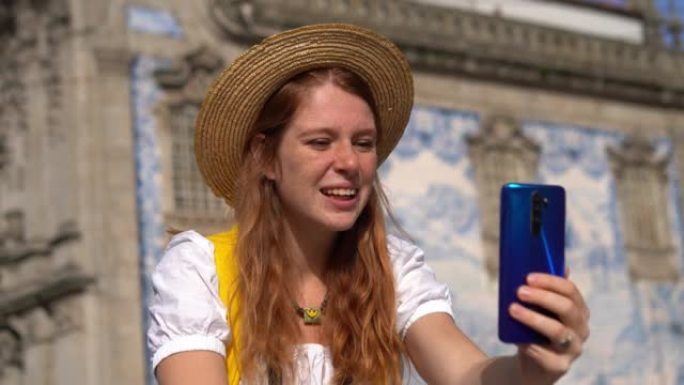 快乐的年轻女子对葡萄牙街进行了视频通话。