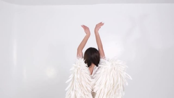 白色背景上有白色翅膀的女人，她以天使的形象举起双手