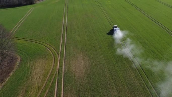 农用拖拉机在春季麦田上撒肥，空中