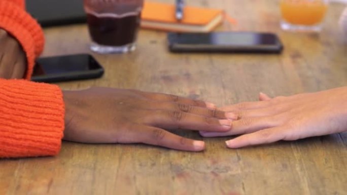 所有颜色的友谊 -- 黑人女孩和白人女孩的手靠近