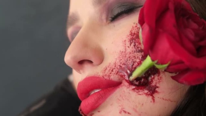 迷人的黑发女人，万圣节化妆，嘴里有玫瑰花。高质量4k视频
