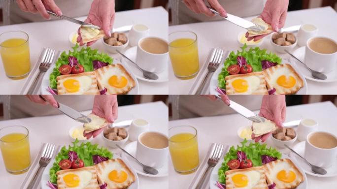 女人在桌子上的烤面包上涂抹黄油，搭配美味的蛋蛋烤面包早餐