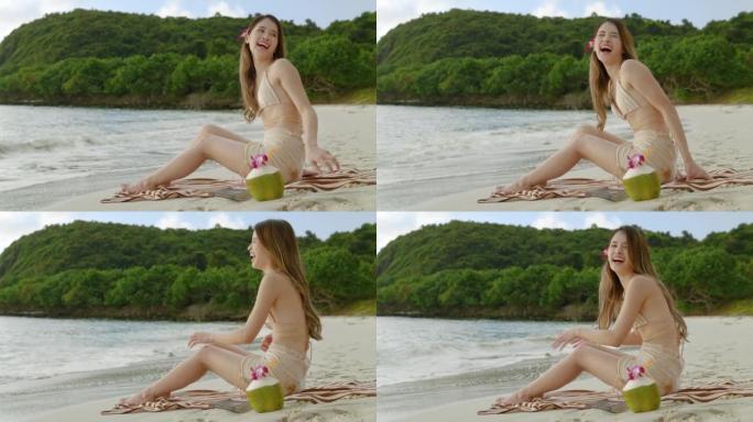 亚洲妇女放松，日光浴，阅读，在海滩上喝椰子水度假。自由、旅行、冒险的概念。