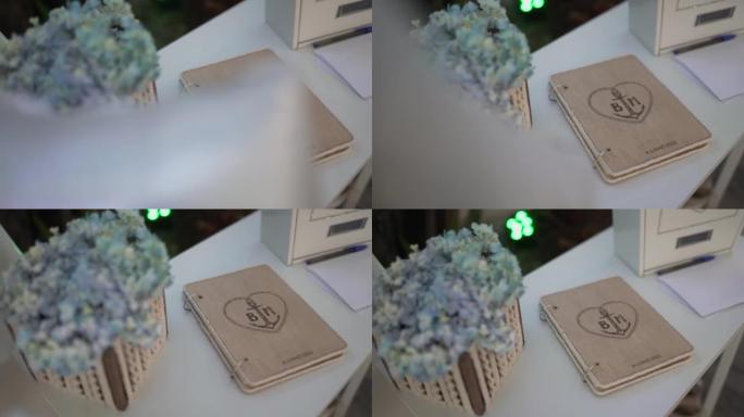 婚礼上美丽的装饰品，一束精致的鲜花和一个木制记事本