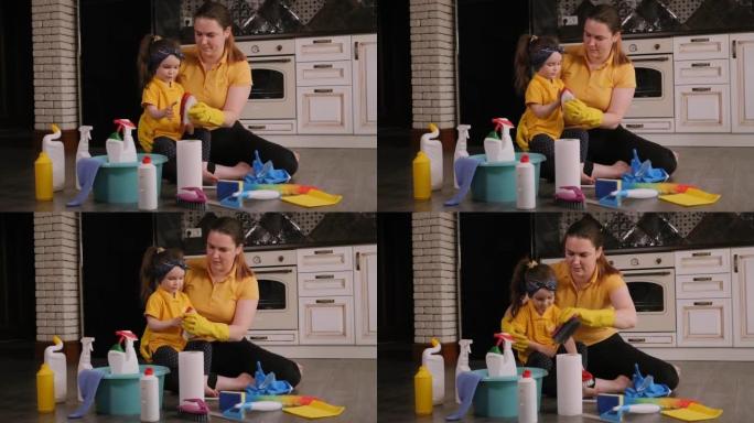 一位母亲和一个小女儿在打扫卫生时在家玩耍的特写镜头。