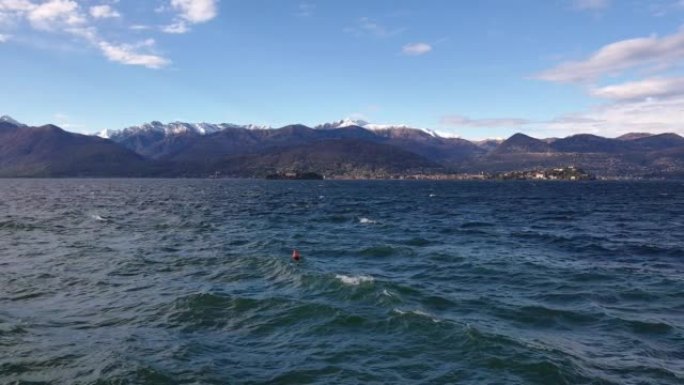 搅动的湖水和Maggiore湖水的孤立浮标，背景是阿尔卑斯山山脉，意大利的斯特雷萨