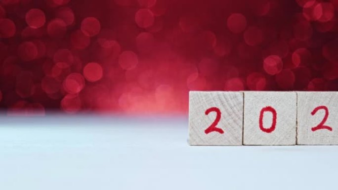 人的手换年号2022年2023年在带有红色数字的木制立方体上