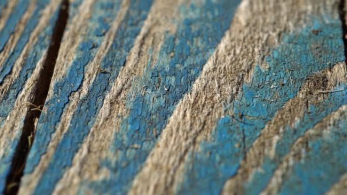 油漆剥落的木墙的缓慢垂直滑动拍摄。慢速多莉的旧彩绘木板，质地。