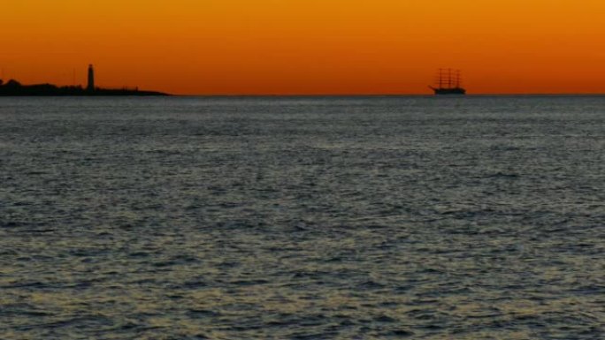 日落时高大的船在大海和灯塔