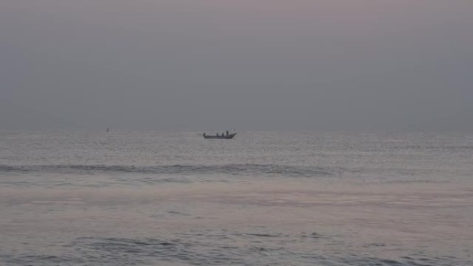 海滩上的早晨日出，渔民乘船